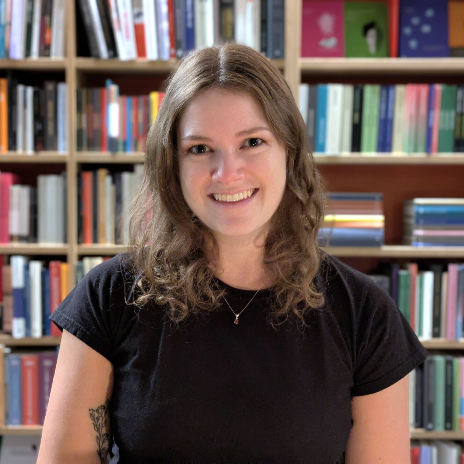 Professor Rebecca Jonas pictured in front of a colorful bookshelf.